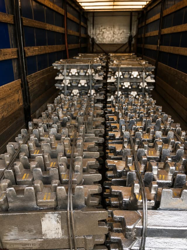 Aluminium alloy ingots stacked in rows inside a truck trailer.